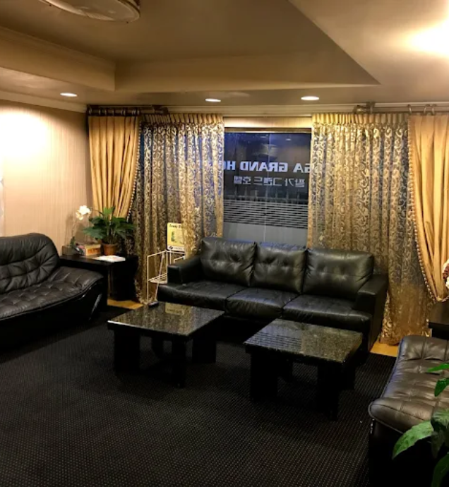 Stylish room showcasing black leather couches and a coffee table, offering an affordable and comfortable stay at Hometel Suites.